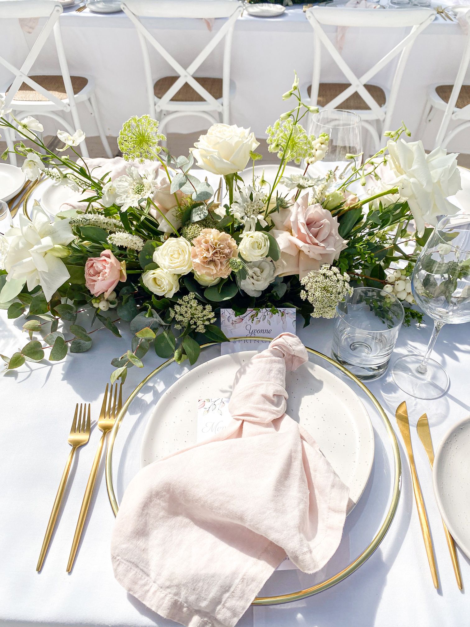 Gold cutlery, gold rim charger and blush napkin, floral centrepieces