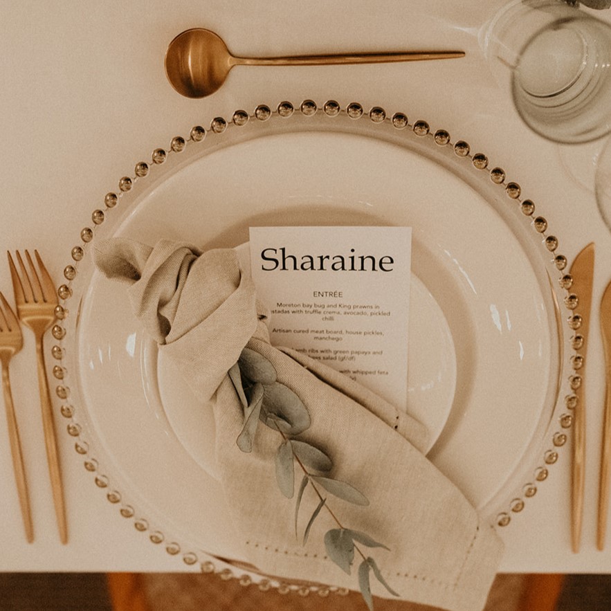 Gold beaded charger, gold cutlery and natural napkin