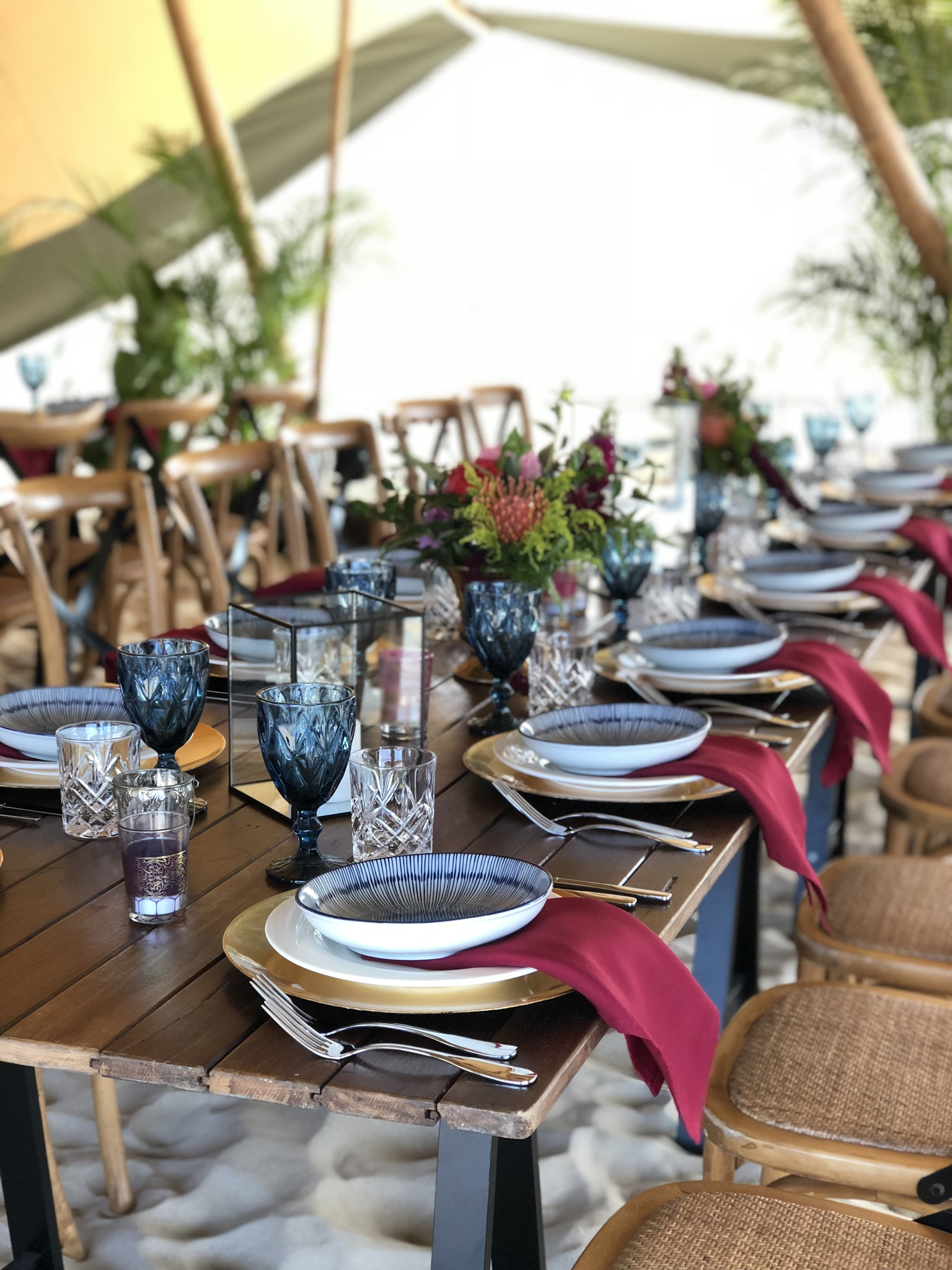 Burgandy napkins, jappa plate and blue glassware
