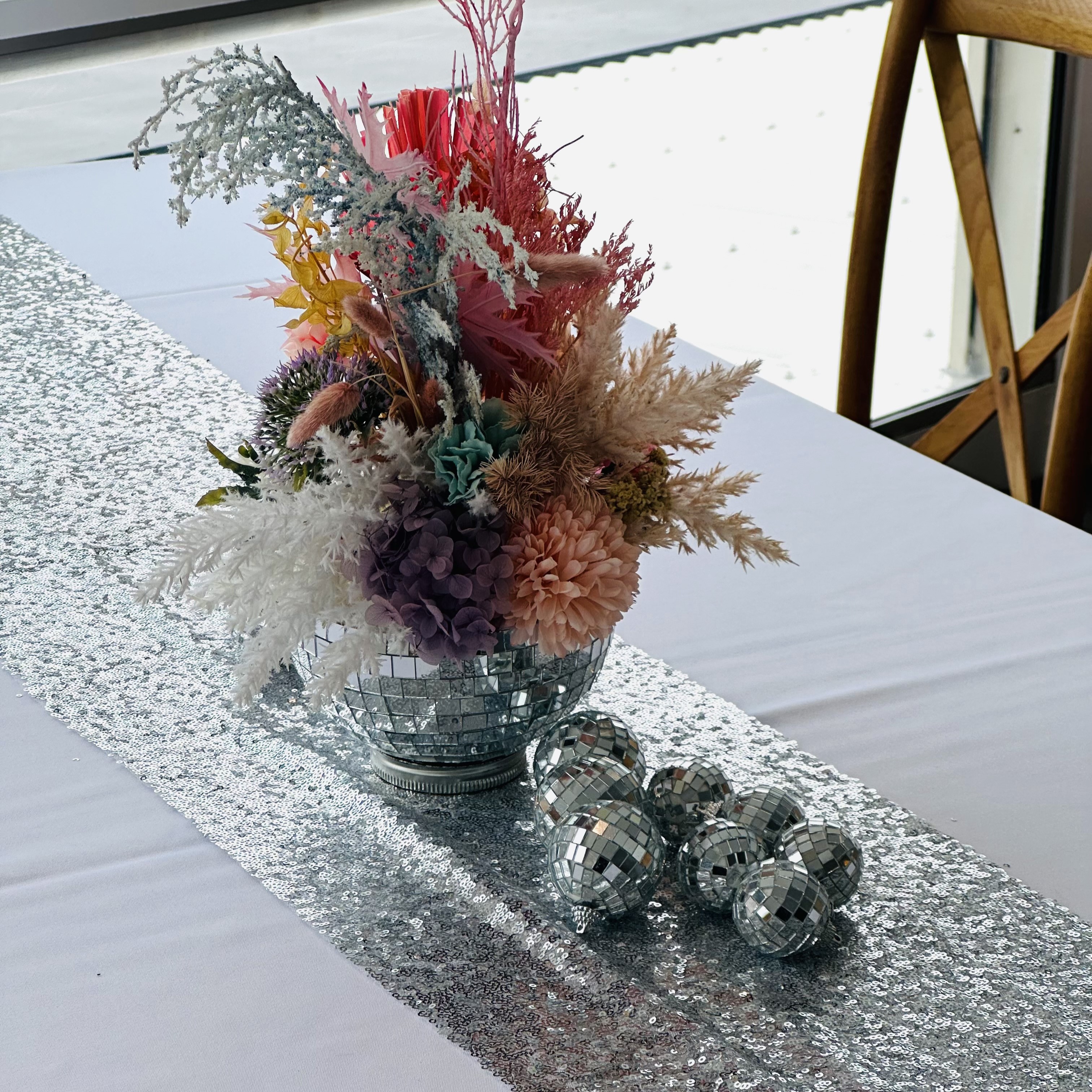 Disco centrepiece with dried flowers, small disco balls and silver table runner