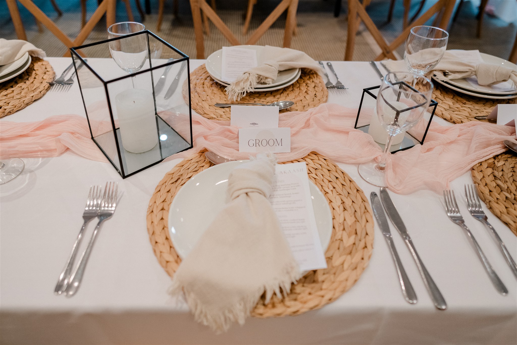 Blush table runner, black lanterns and woven charger plates