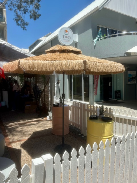 White picket fence, seagrass umbreall and oil drums