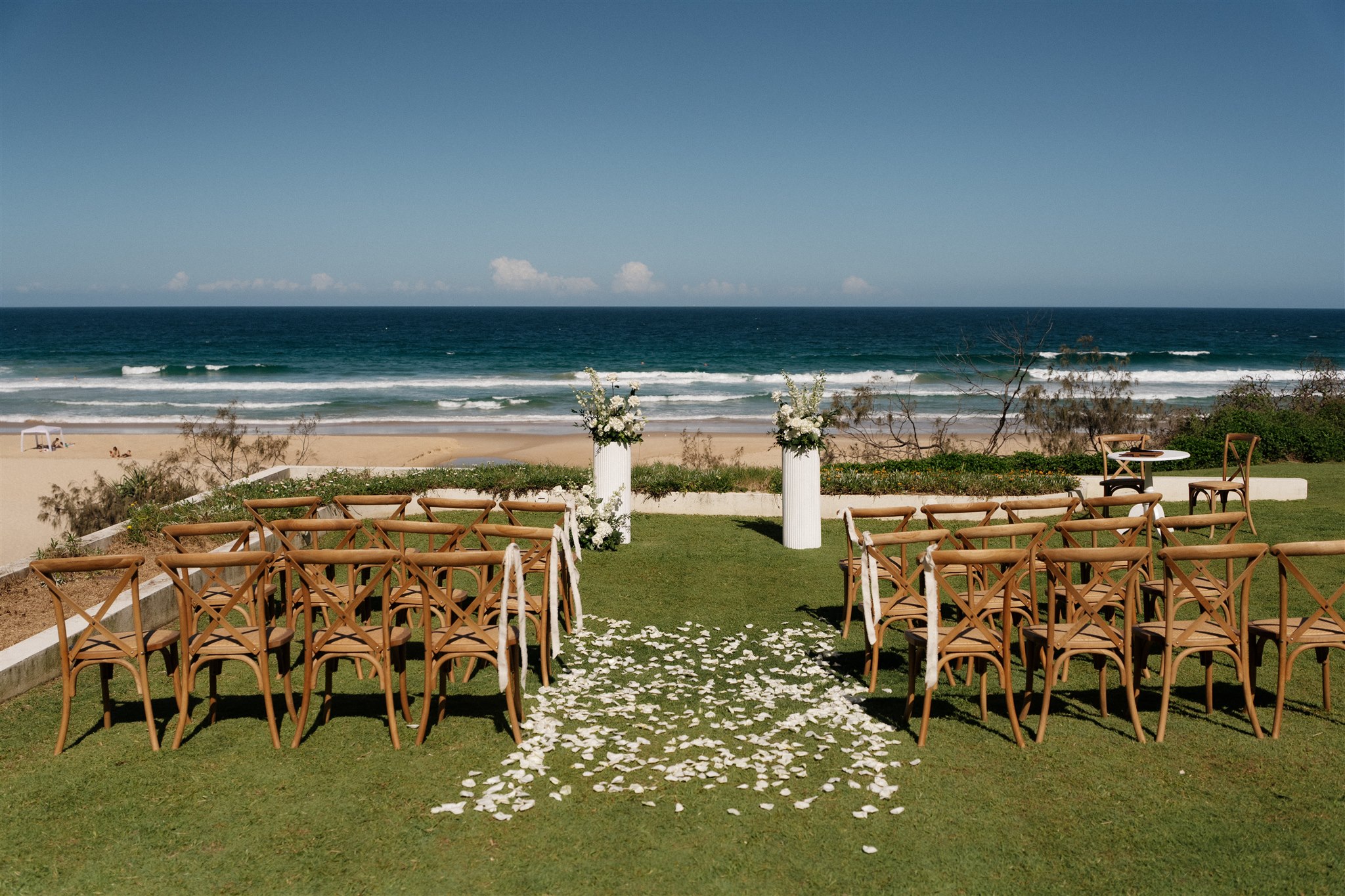 Natural Hampton Chairs, ribbed plinths, petal aisle ceremony